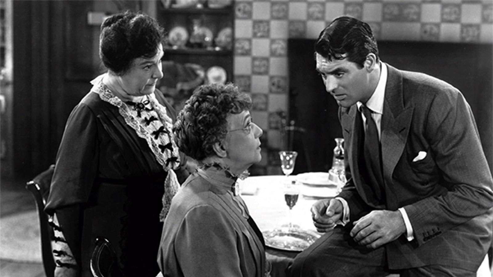 Still from the 1944 film Arsenic and Old Lace showing Josephine Hull, Jean Adair, and Cary Grant from left to right