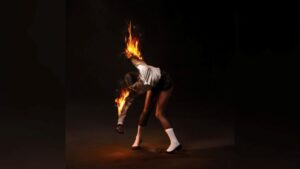 ‘All Born Screaming’ Review: St. Vincent Finds Catharsis in Compelling New Album The album cover artwork for St. Vincent's latest record, "All Born Screaming," featuring band leader Annie Clark bending over while her arms are on fire in front of a black backdrop.