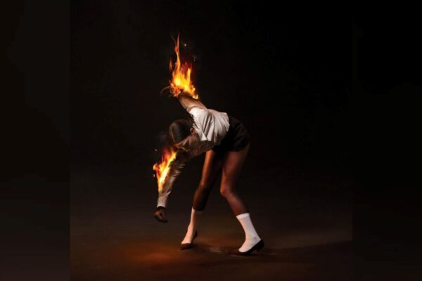 The album cover artwork for St. Vincent's latest record, "All Born Screaming," featuring band leader Annie Clark bending over while her arms are on fire in front of a black backdrop.
