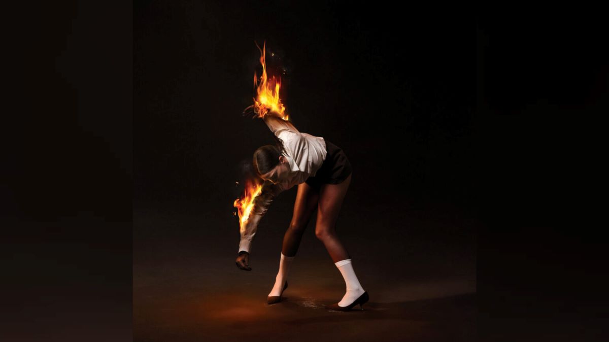 The album cover artwork for St. Vincent's latest record, "All Born Screaming," featuring band leader Annie Clark bending over while her arms are on fire in front of a black backdrop.