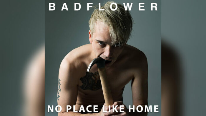 Badflower’s ‘No Place Like Home’ Digs Deep — Album Review Album cover for Badflower's "No Place Like Home," featuring lead vocalist Josh Katz posing shirtless while sticking a hammer in his mouth on a gray background.