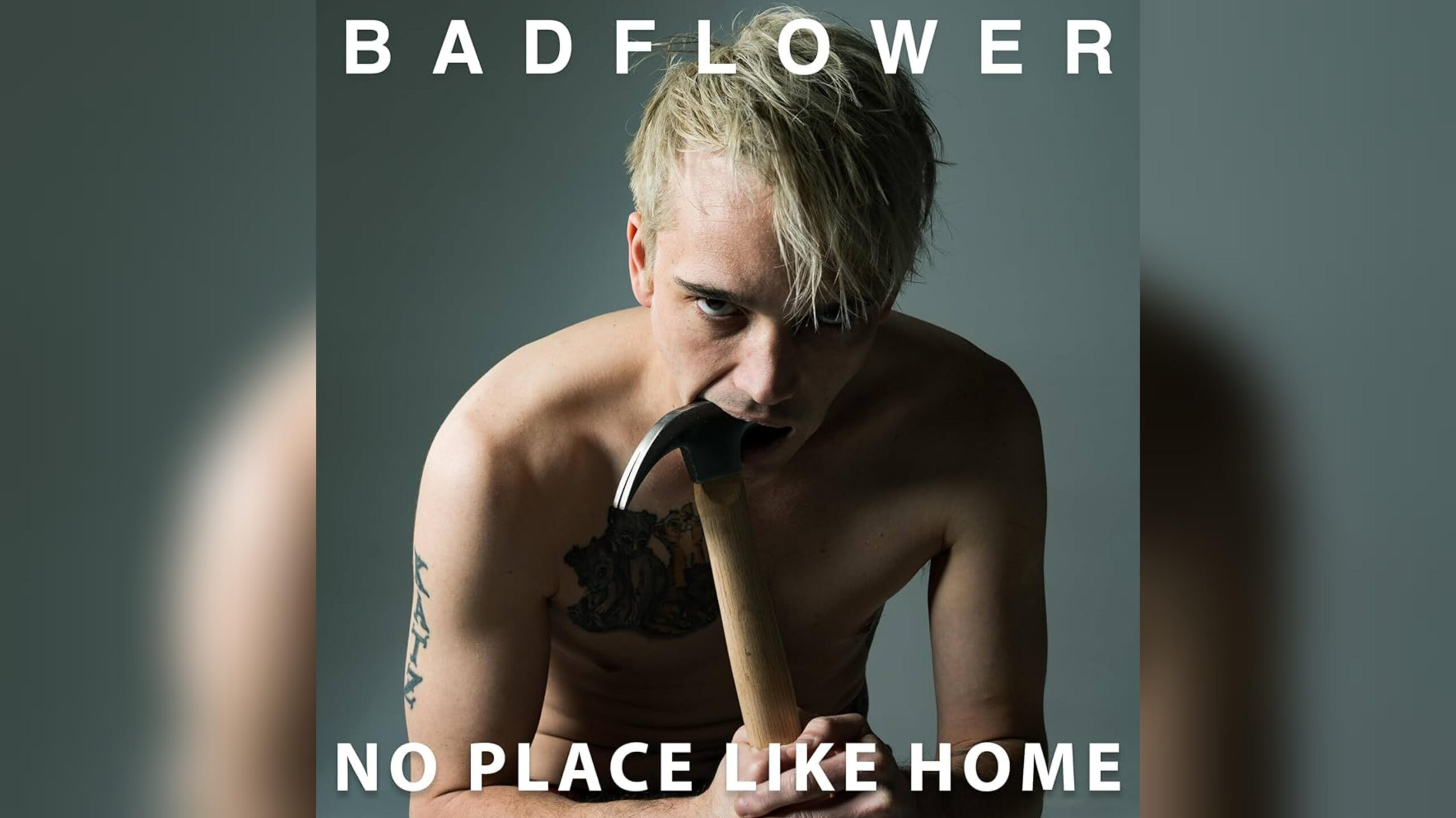 Badflower’s ‘No Place Like Home’ Digs Deep — Album Review Album cover for Badflower's "No Place Like Home," featuring lead vocalist Josh Katz posing shirtless while sticking a hammer in his mouth on a gray background.