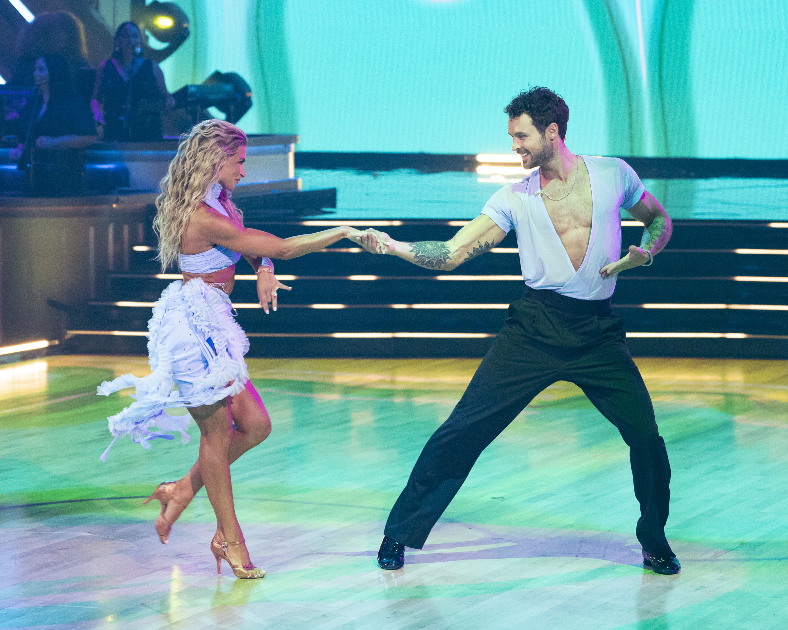 Duo Daniella and Dylan wearing blue performance attire, dancing in the ballroom