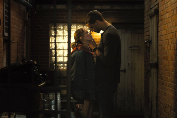 Tyriq Withers as Ledger Ward and Maika Monroe as Kenna Rowan stand close together in a dimly lit alley