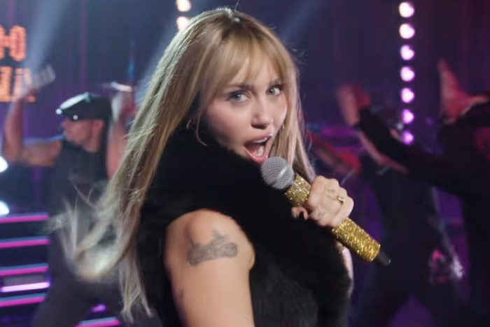 Hannah Montana 20th Anniversary Special Review: Miley Cyrus Brings Fans Back to Where It All Began Miley Cyrus singing into a microphone during a high-energy performance on stage