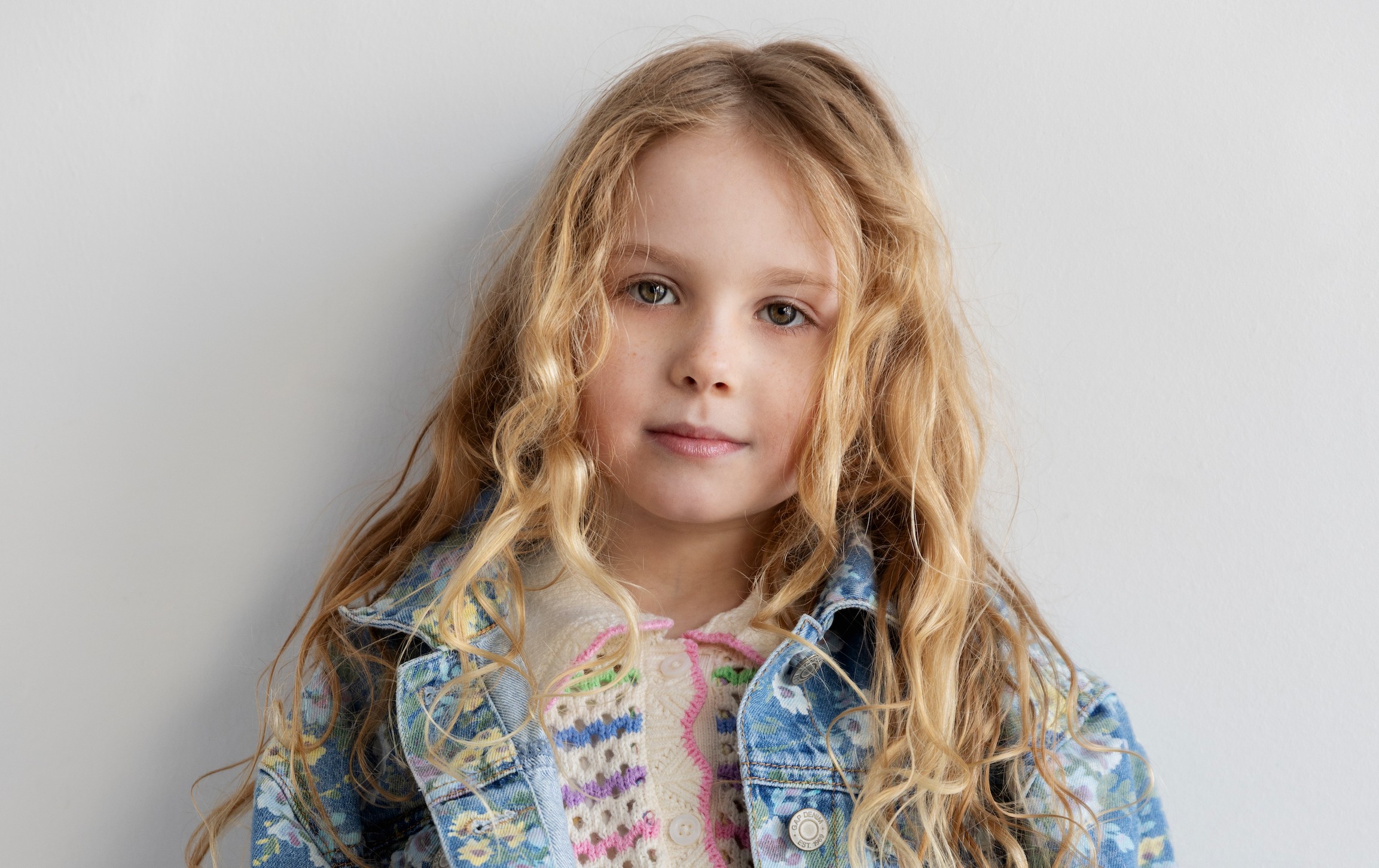 Actress Zoe Kosovic, who stars in Reminders of Him, poses for a headshot photo in front of a gray background.