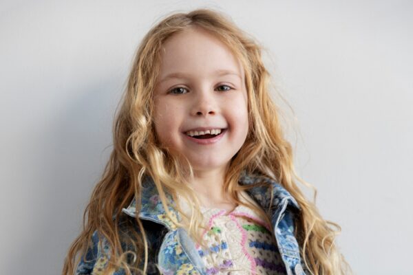 Actress Zoe Kosovic, who stars in Reminders of Him, poses for a headshot photo in front of a gray background.