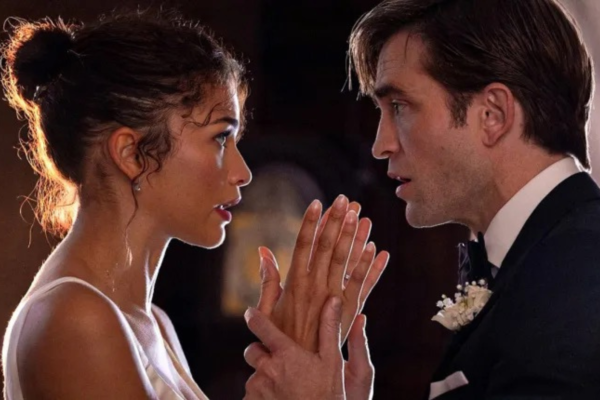 Zendaya as Emma and Robert Pattinson as Charlie in The Drama. (Photo courtesy of A24). Zendaya and Robert Pattinson face each other closely in formal attire, holding hands with intense expressions