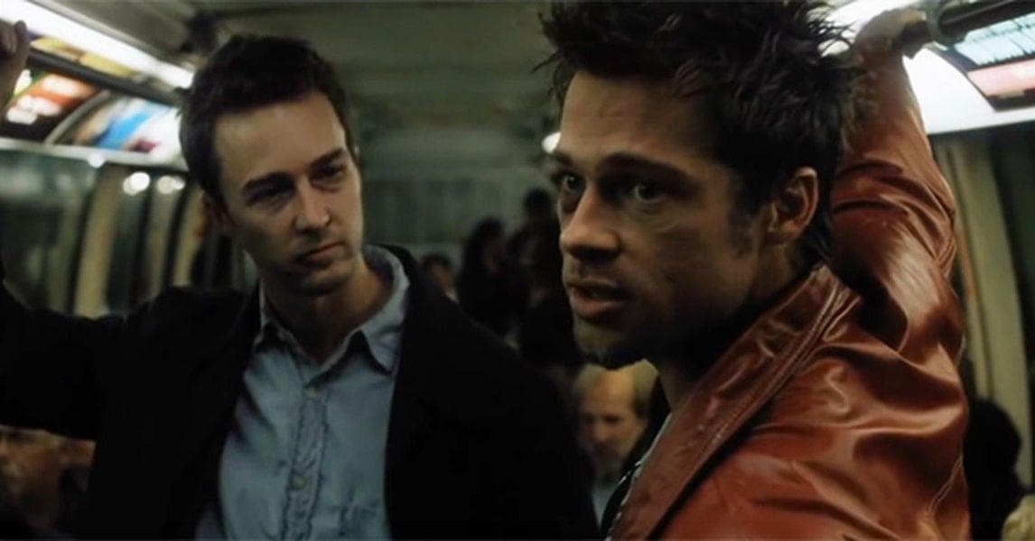 Fight Club 4K Remaster Review: Tyler Durden Returns to the Big Screen in David Fincher’s Masterpiece Two men on a subway car; one in a brown leather jacket gazes toward the camera while the other looks on.
