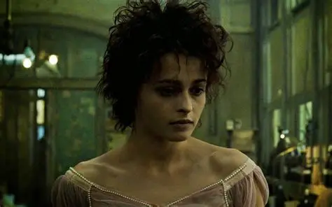 Fight Club 4K Remaster Review: Tyler Durden Returns to the Big Screen in David Fincher’s Masterpiece Woman with short dark hair in a pale pink off-shoulder dress stands in a dim, green-lit room, looking down with a somber expression.