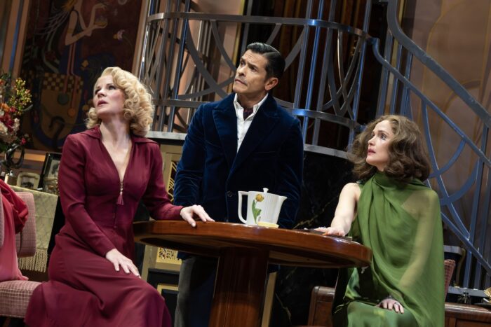 Fallen Angels on Broadway Review: These Angels Fly Away with Big Laughs Three actors sit around a round wooden table on a vintage theater set, looking upward with concerned expressions.