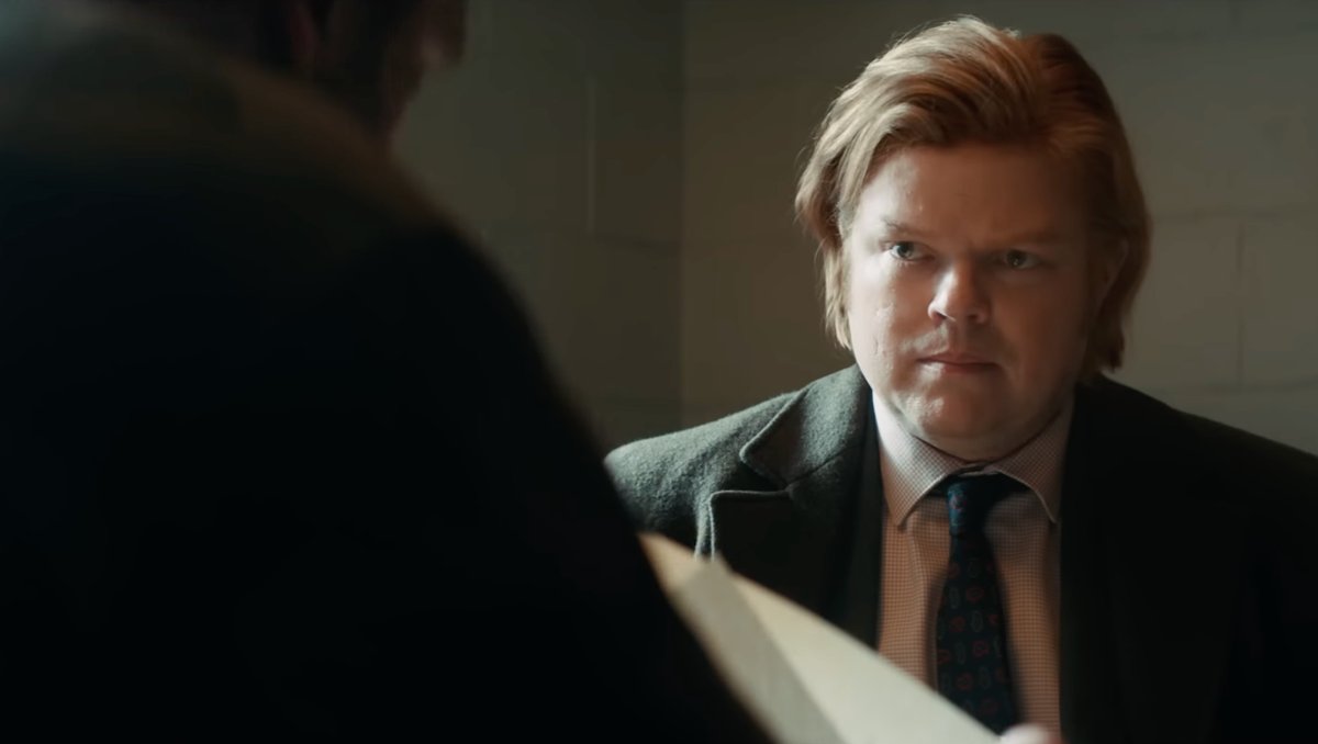 Daredevil: Born Again Season 2 Episode 5 Review: ‘The Grand Design’ Is A Greater Metaphor Man in a suit and tie with blond hair, looking serious while examining a document in a dimly lit room