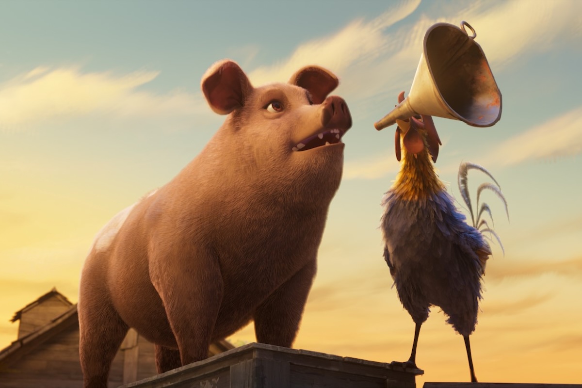 Animal Farm Review: George Orwell Fans May Be Underwhelmed by This Interesting Misfire Pig standing on a ledge as a rooster with a megaphone speaks to it at sunset on a barn roof.