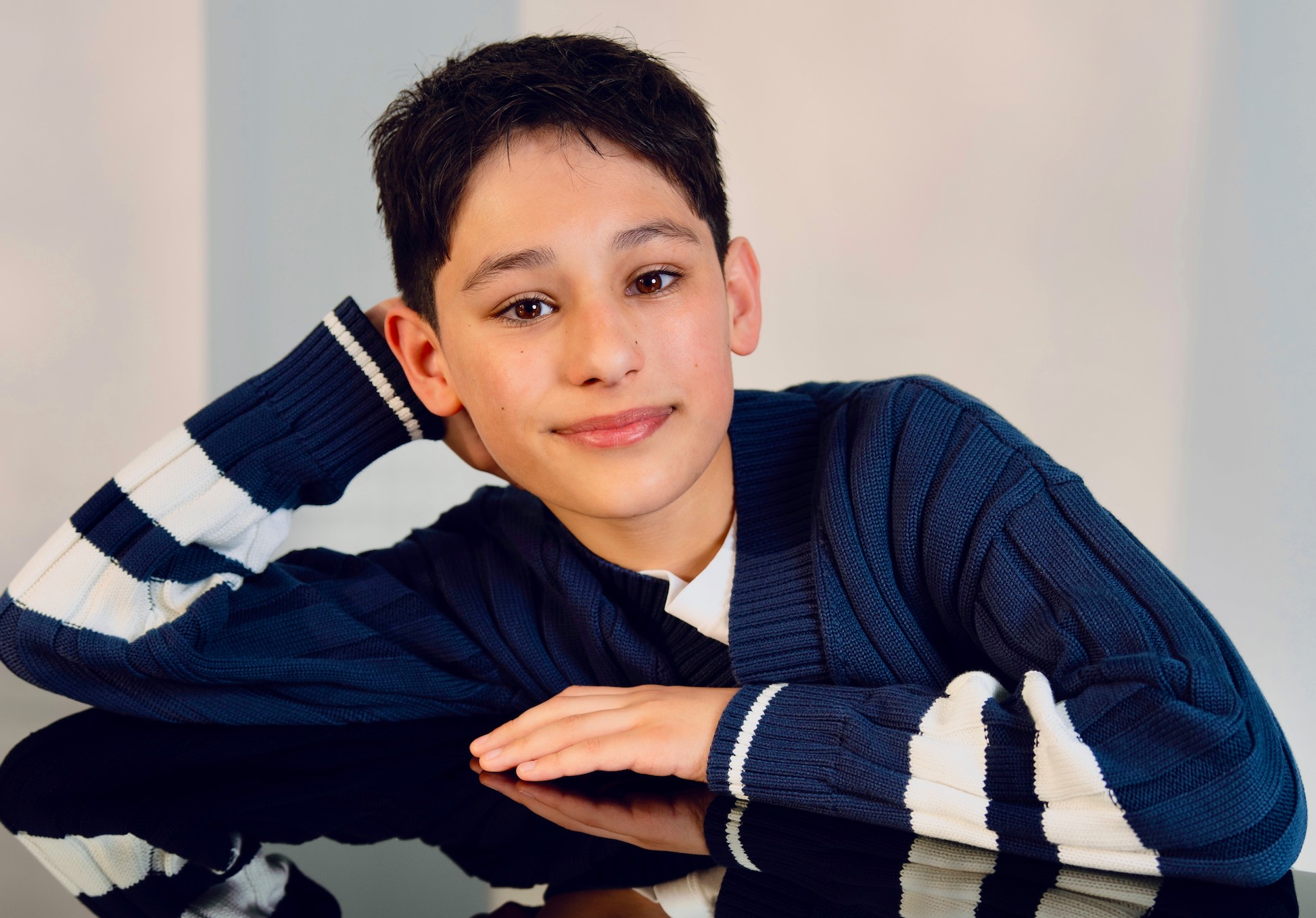 Rain Janjua on Voicing Chase in PAW Patrol: The Dino Movie Actor Rain Janjua poses for a headshot photo while facing forward, smiling for the camera.