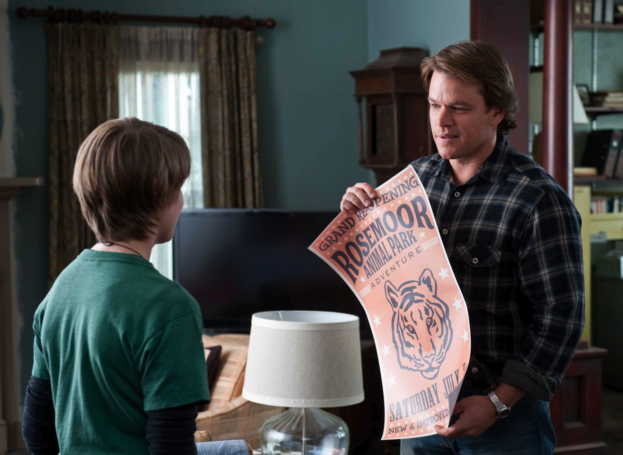 The 12 Best Movies Featuring Matt Damon in a Principal Role Man in a plaid shirt hands a large pink poster to a child in a green shirt inside a living room.
