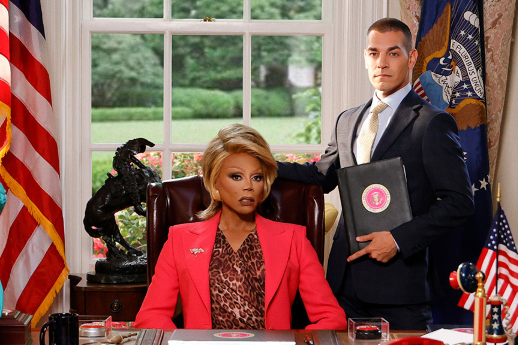 A Presidential Response - Eulalie Magazine Stop! That! Train! Review: A First-Class Campy Comedy President Judy Gagwell sits behind her desk in the Oval Office while an aide stands nearby holding an official briefing folder.