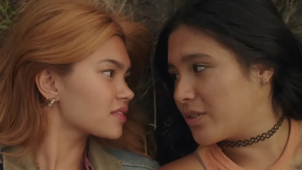 Girls Like Girls Review: Heartbreak Feels Good in a Movie Like This Two women face each other closely outdoors, one with light brown hair and the other with black hair, engaged in conversation.