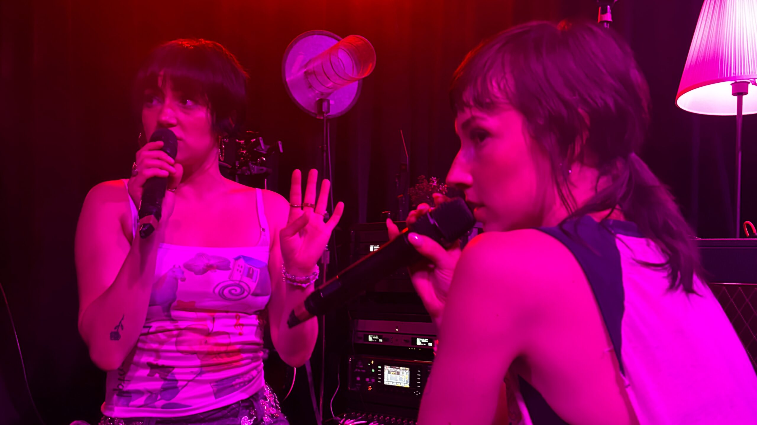 IMG_6215 - Eulalie Magazine Daisy Grenade’s First Headline Tour is an Explosive, Memorable Debut Two female performers sing into handheld microphones on a lit stage, facing each other.