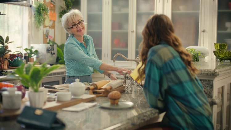 Joel Courtney and Andy Delaney Talk 40 Dates and 40 Nights, Dating Red Flags, and Empathy Friendly older woman with glasses helps a customer at a bright kitchen counter, surrounded by baking tools and plants in a store.