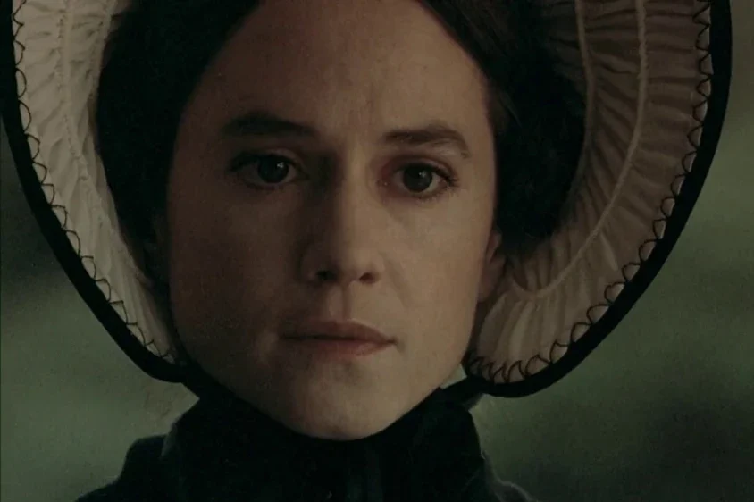 The Piano 4K Restoration Review: Holly Hunter’s Performance Ages Like Fine Wine in a Sweeping Film Close-up of a woman wearing a Victorian-style bonnet, looking somberly ahead.